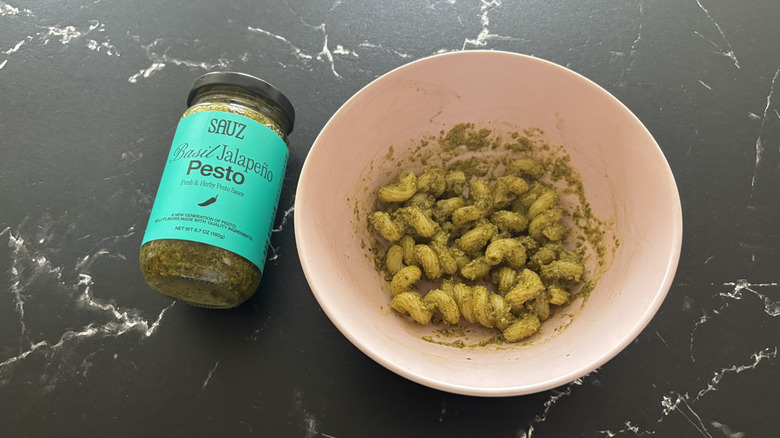 Sauz pesto jar next to pesto pasta in bowl