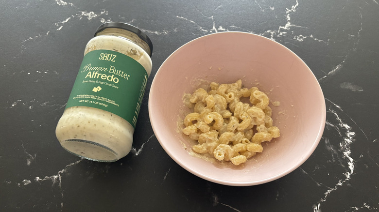 Sauz brown butter Alfredo sauce jar next to Alfredo pasta in bowl