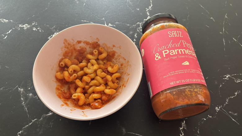 Sauz pepper and parmesan pasta sauce jar next to bowl of pasta