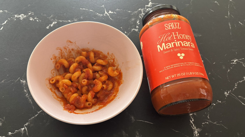 Bowl of pasta with sauce next to Sauz hot honey marinara jar
