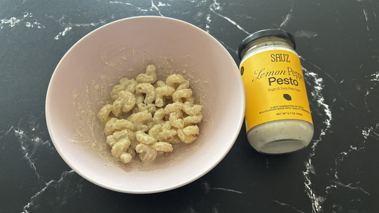 Bowl of pasta next to Sauz lemon pepper pesto jar