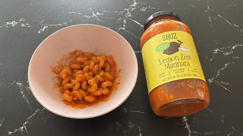 Bowl of pasta with sauce next to Sauz lemon marinara jar