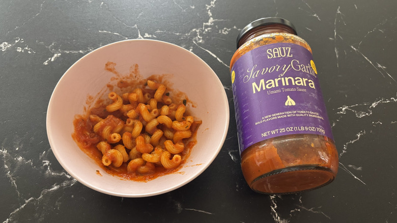 Bowl of pasta next to Sauz garlic marinara jar