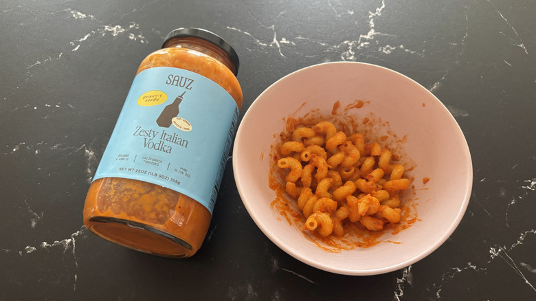 Sauz Italian vodka sauce jar next to bowl of pasta with sauce