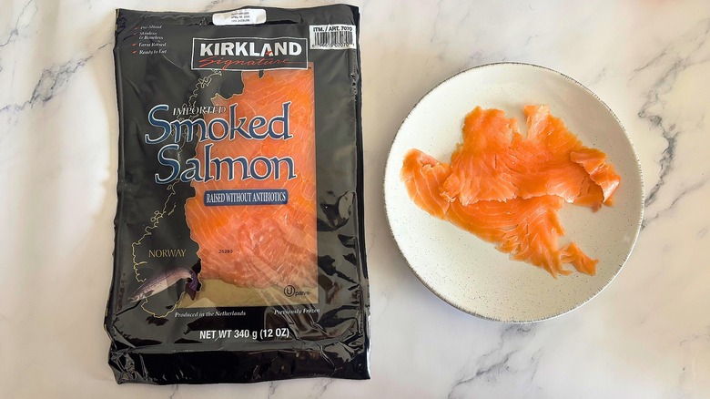 Kirkland smoked salmon on white plate next to packaging on white marble surface
