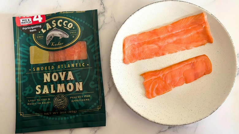 Lascco smoked salmon on white plate next to packaging on white marble surface