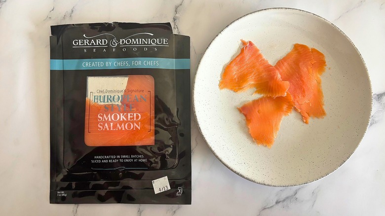 Gerard & Dominique smoked salmon on white plate next to packaging on white marble surface