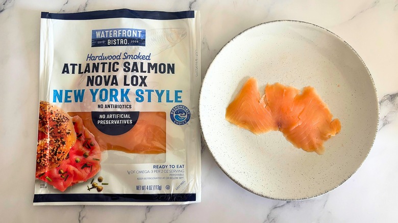 Waterfront Bistro smoked salmon on white plate next to packaging on white marble surface