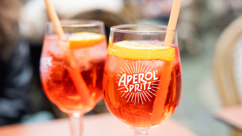 Two glasses of Aperol Spritz with straws