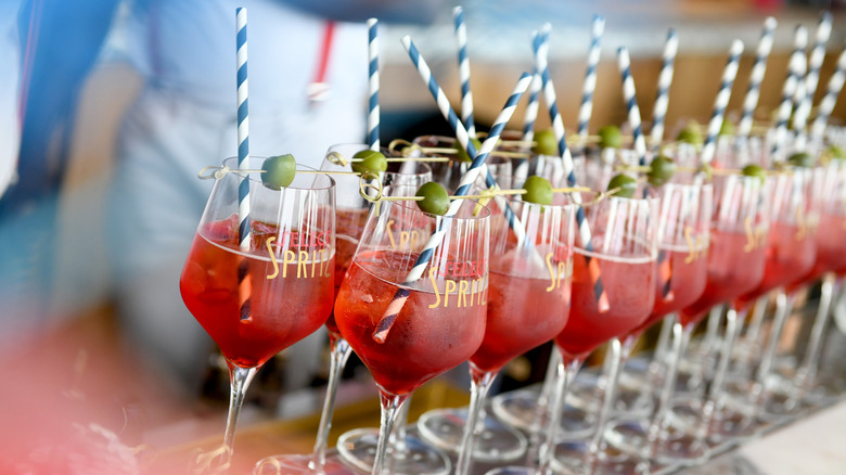Multiple glasses of Select Spritz with olive garnish and straws