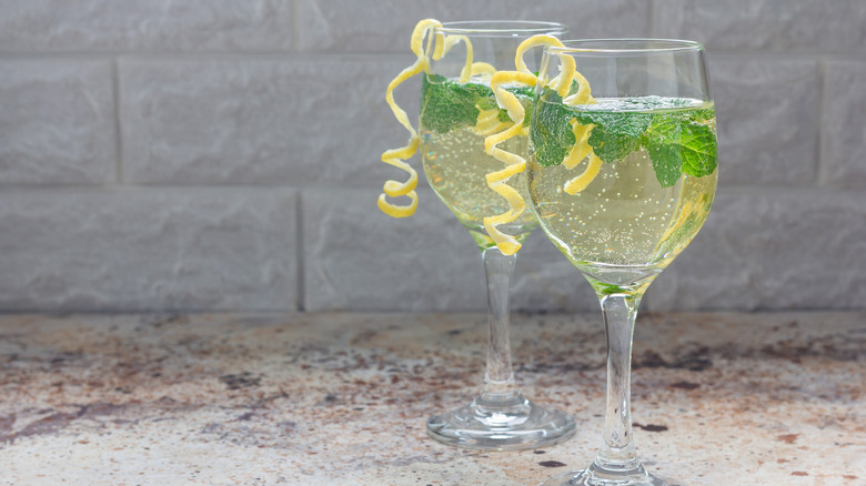 Two glasses of White Wine Spritz with lemon and mint garnish