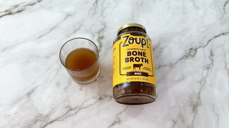 Jar of Zoup! beef bone broth and glass of broth