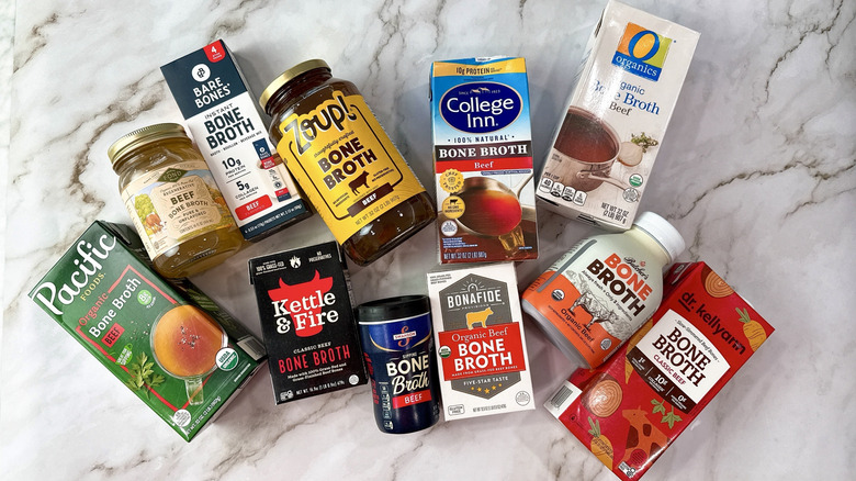 11 different brands of beef bone broth on a marble counter