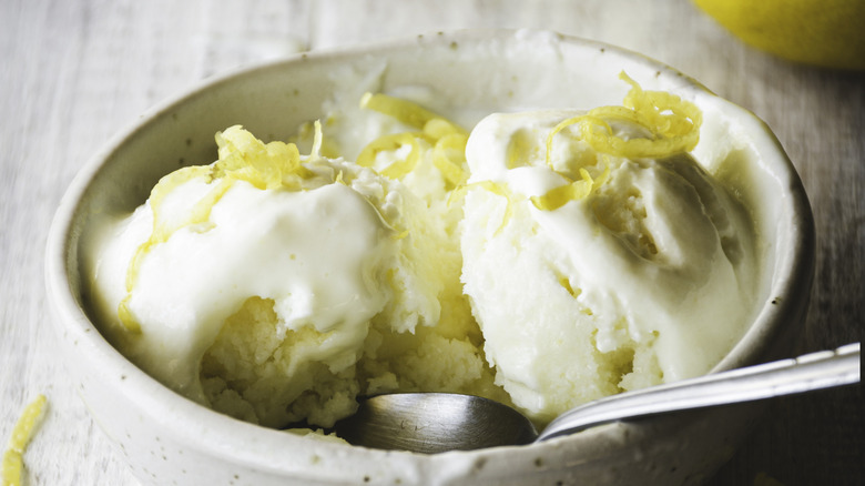 Creamy ice cream in a bowl with lemon zest garnish