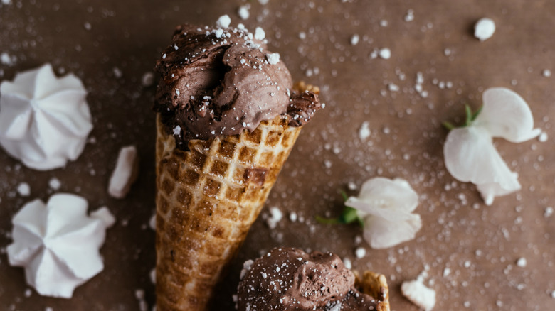 Chocolate ice cream in a cone, topped with crushed meringue