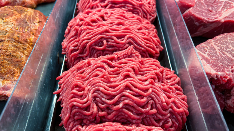 Ground burger in butcher display case.