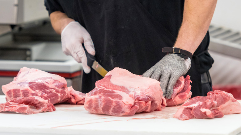 Butcher cutting large slab of meat
