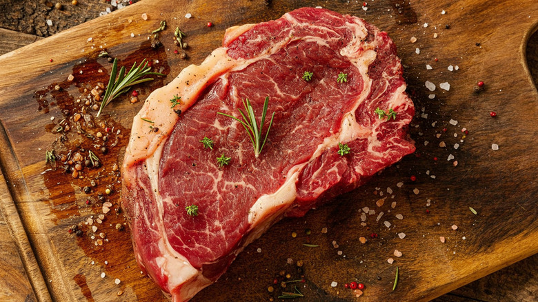 Raw steak seasoned with salt and pepper