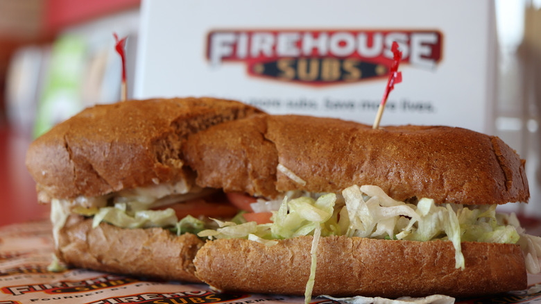 A sliced submarine sandwich in front of a Firehouse Subs logo