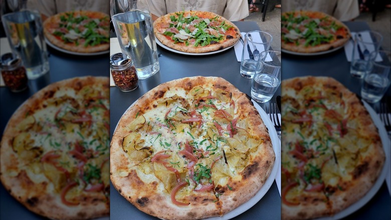 Two pizzas on a black dining table