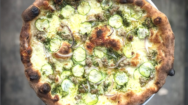 A zucchini and onion pizza with a blistered crust