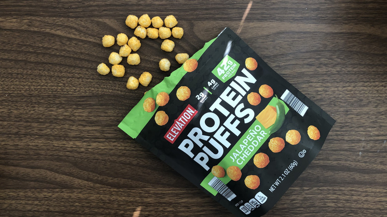 A box of Aldi Elevation jalapeño cheddar protein puffs with some spilling out