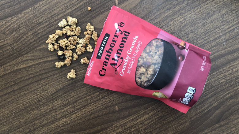 A bag of Aldi Millville cranberry and almond protein granola with some spilling out