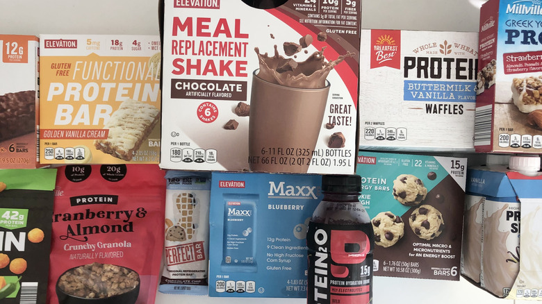 Aldi protein snacks and drinks piled at a table