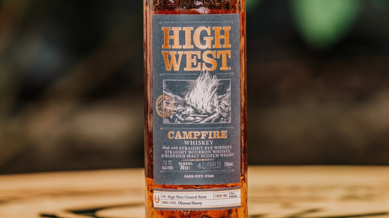 A close up of a bottle of High West Distillery Campfire Whiskey with a blurred outdoors background