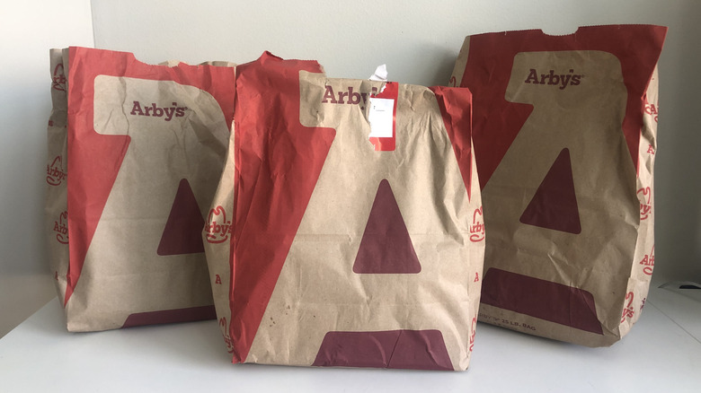 3 To-go bags full of Arby's sandwiches.