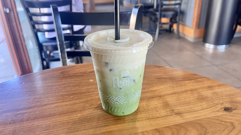 Peet's Coffee Protein Banana Matcha Oat Latte in a plastic cup on a table