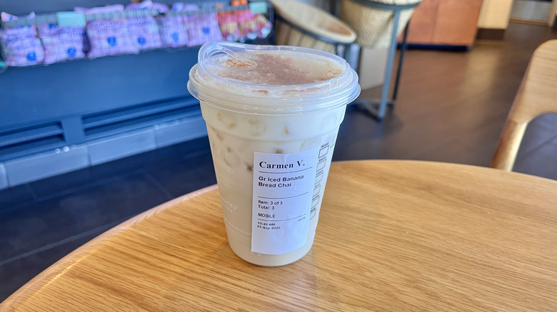 Starbucks Iced Banana Bread Chai on a table served in a plastic cup with cinnamon on top