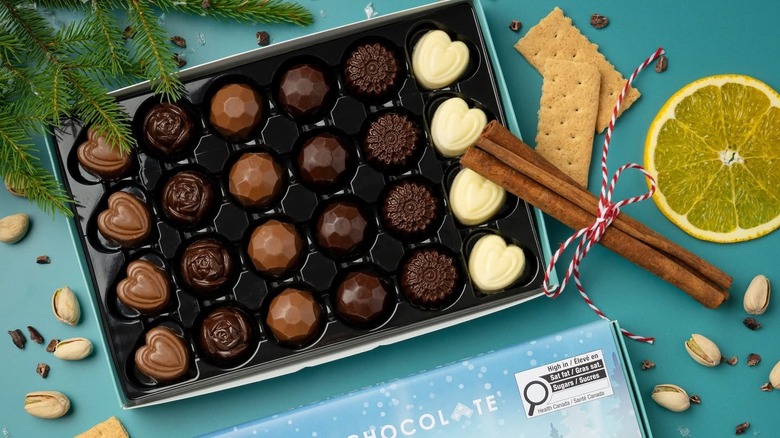 Overhead image of opened box of chocolates on blue background