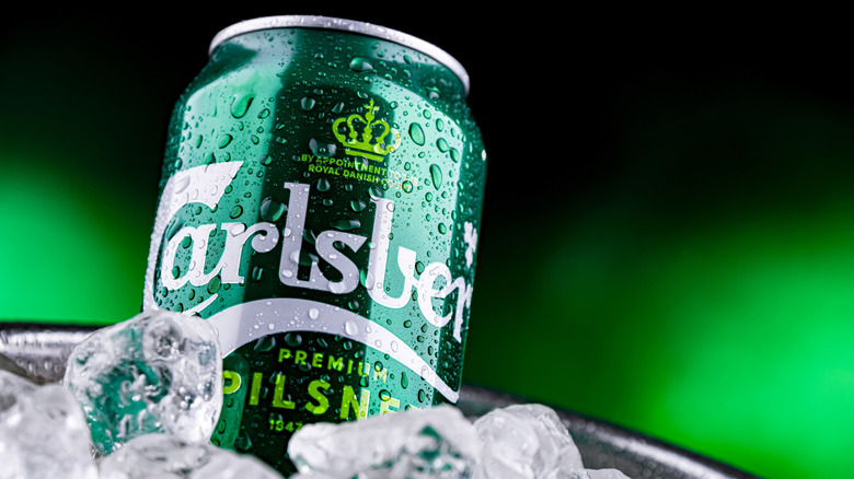 Can of Carlsberg in ice on green background