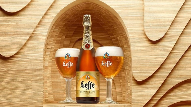 Bottle of Leffe with two glasses in carved wooden alcove