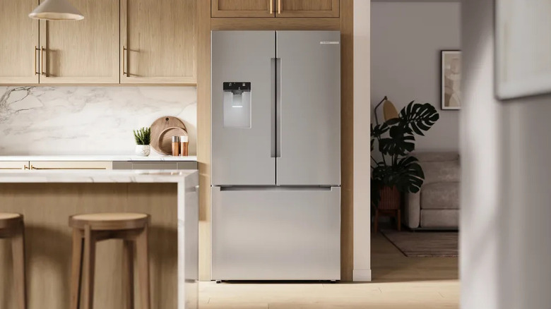A Bosch French door refrigerator installed in a modern, open floor plan kitchen