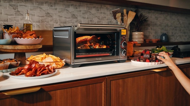 A Breville Smart oven on a kitchen counter with a roast chicken inside