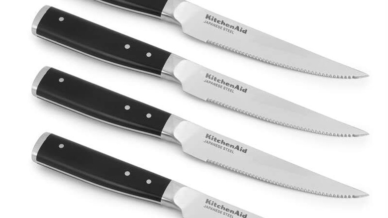 A product shot of four KitchenAid Gourmet steak knives shown on a plain white background