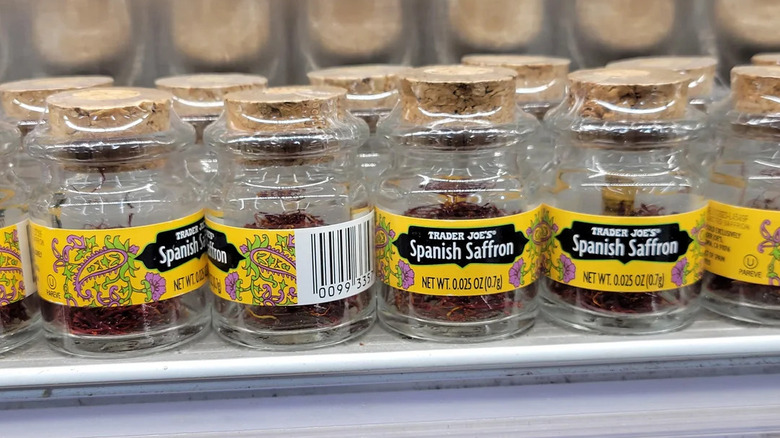 Several small glass jars of saffron on shelf