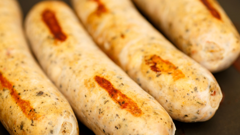 Close up of chicken sausages browning in pan