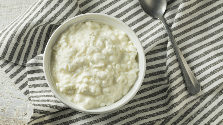Bowl of cottage cheese on grey striped linen