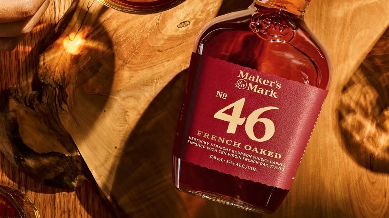 An overhead shot of a bottle of Maker's Mark 46 laid on its back on a wooden surface
