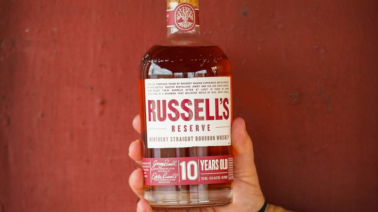 A person's hand showing a bottle of Russell's Reserve 10-Year up to the camera