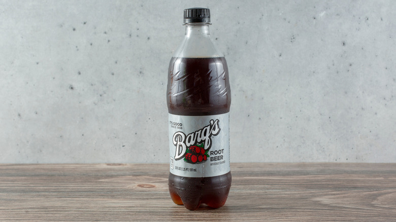 A single plastic bottle of Barq's root beer placed on a wooden surface.