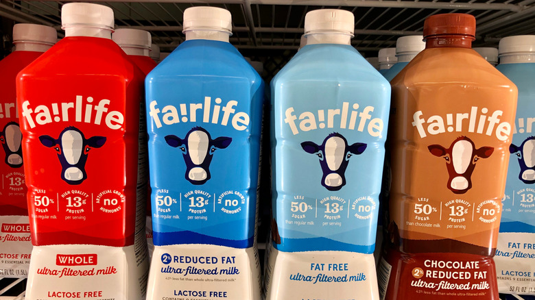Four different types of Fairlife milk cartons inside a store fridge.