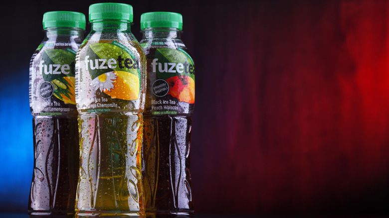 Three Fuze Tea bottles on display with a red and blue background.
