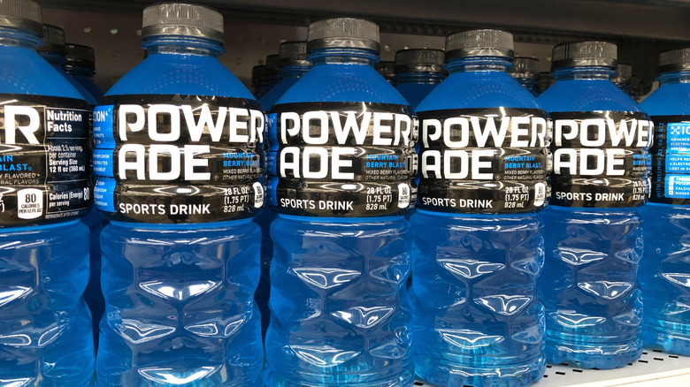 Blue bottles of Powerade sports drink lined up in a store.