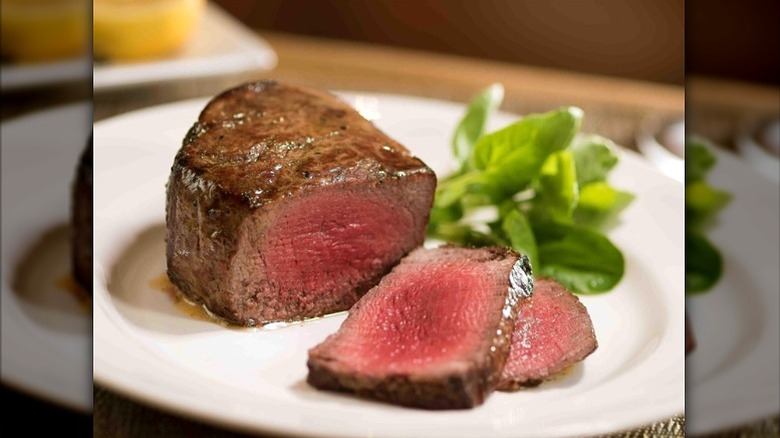 The Capital Grille sliced filet mignon with herbs on plate