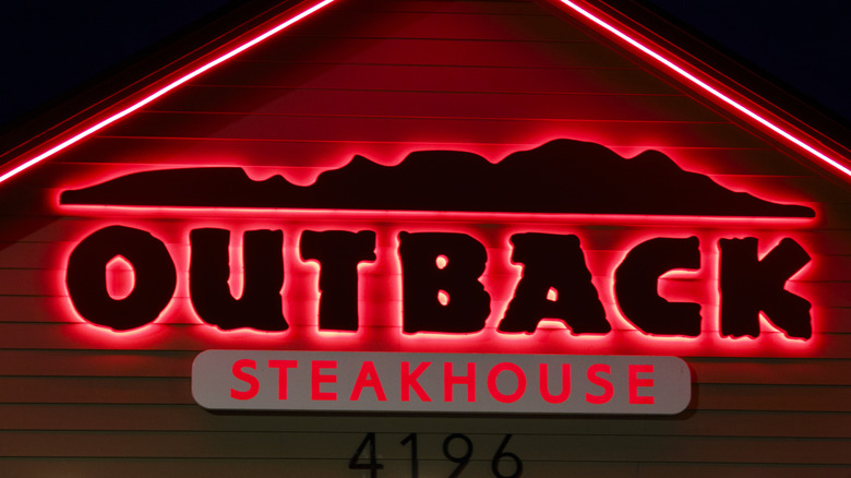 Lit-up Outback Steakhouse sign on building