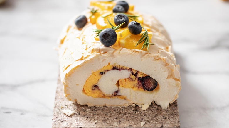A lemon and blueberry meringue roulade on a marble block